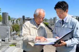 一宮市周辺の地域墓地で墓地管理委員長が管理台帳を確認している様子